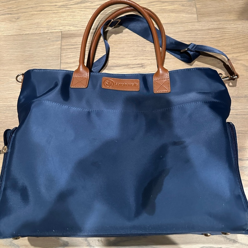 Blue vinyl Sarah Wells pump bag with brown letter handle and 2 pockets for pump